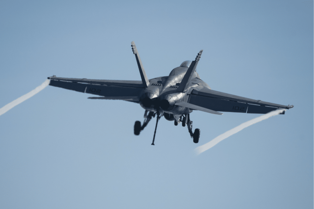 Fighter jet ascending with vapor trails